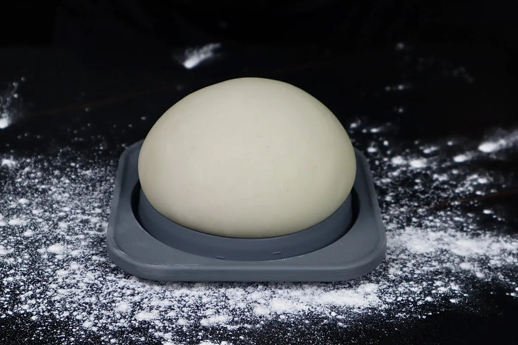 Close view of a relaxed 48-hour cold-fermented pizza dough ball in a KEVJES container