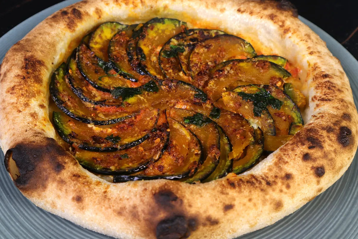 Finished pizza made with 70 percent hydration dough, showing a well-risen and evenly browned crust