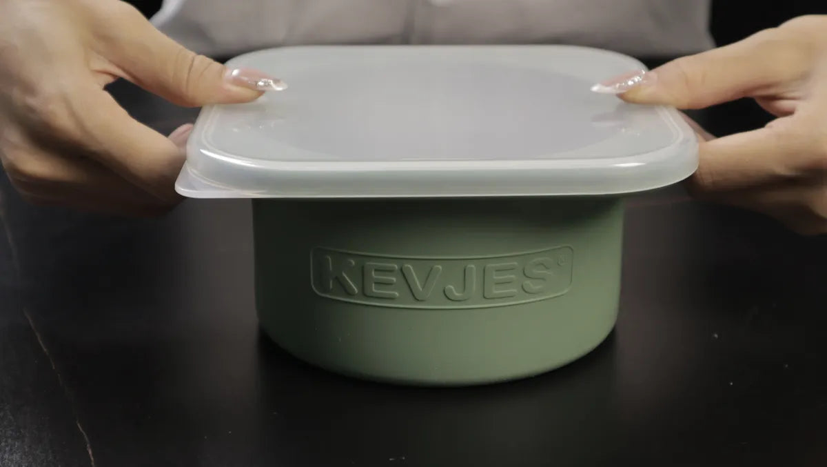 Hands closing the plastic lid tightly over a green KEVJES pizza dough proofing container